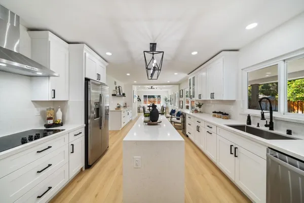 a large kitchen with stainless steel appliances lots of counter space and windows