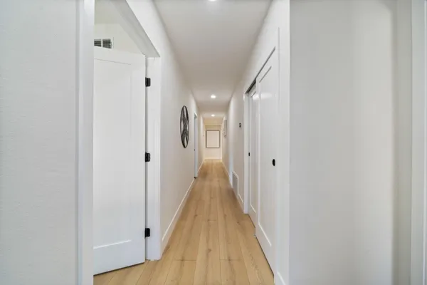 a view of a hallway with wooden floor