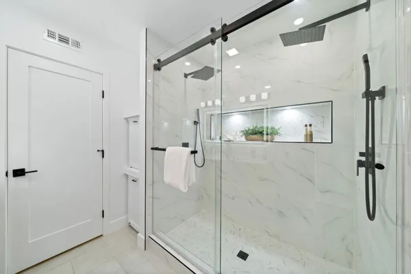 a bathroom with a shower and a glass door
