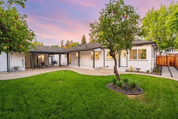 a view of a house with backyard and sitting area