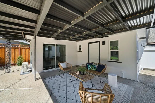 a view of a patio with a table and chairs and potted plants