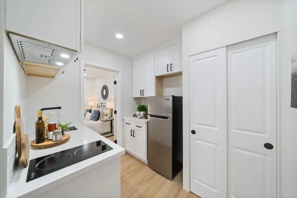a kitchen with a stove and wooden floor