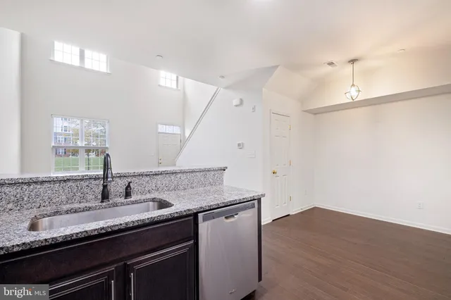 a kitchen with a sink cabinets and wooden floor