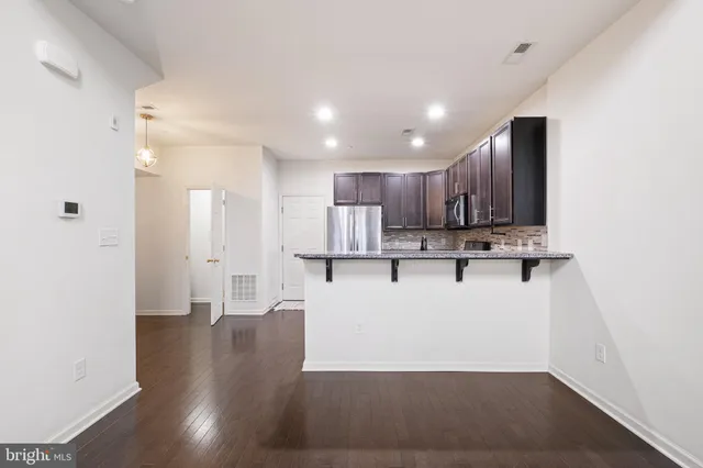 a view of kitchen with stainless steel appliances refrigerator sink and cabinets