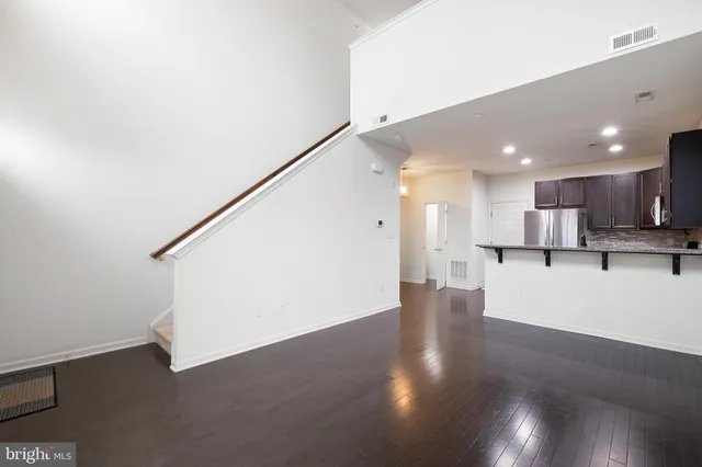 a view of kitchen with kitchen island white cabinetry and wooden floor