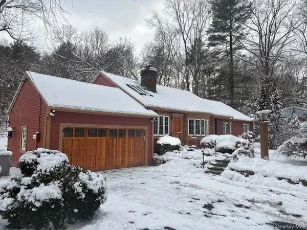 a front view of a house with a yard covered in snow