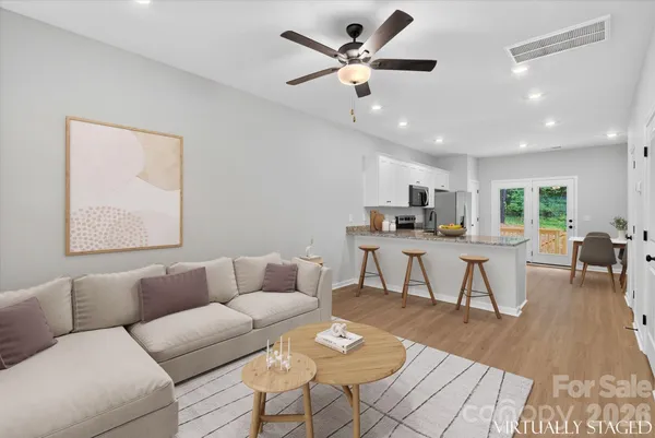 a living room with furniture and kitchen view