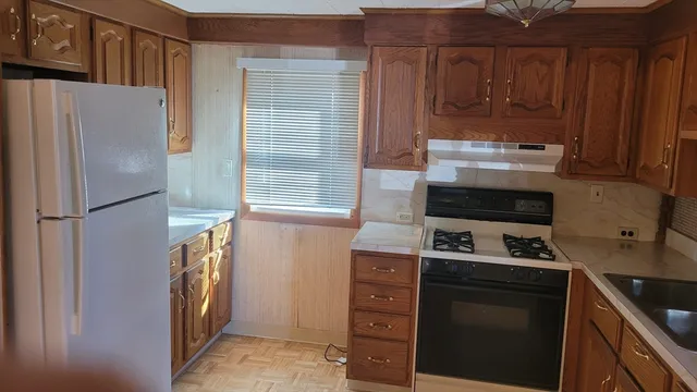 a kitchen with stainless steel appliances a refrigerator and a stove top oven
