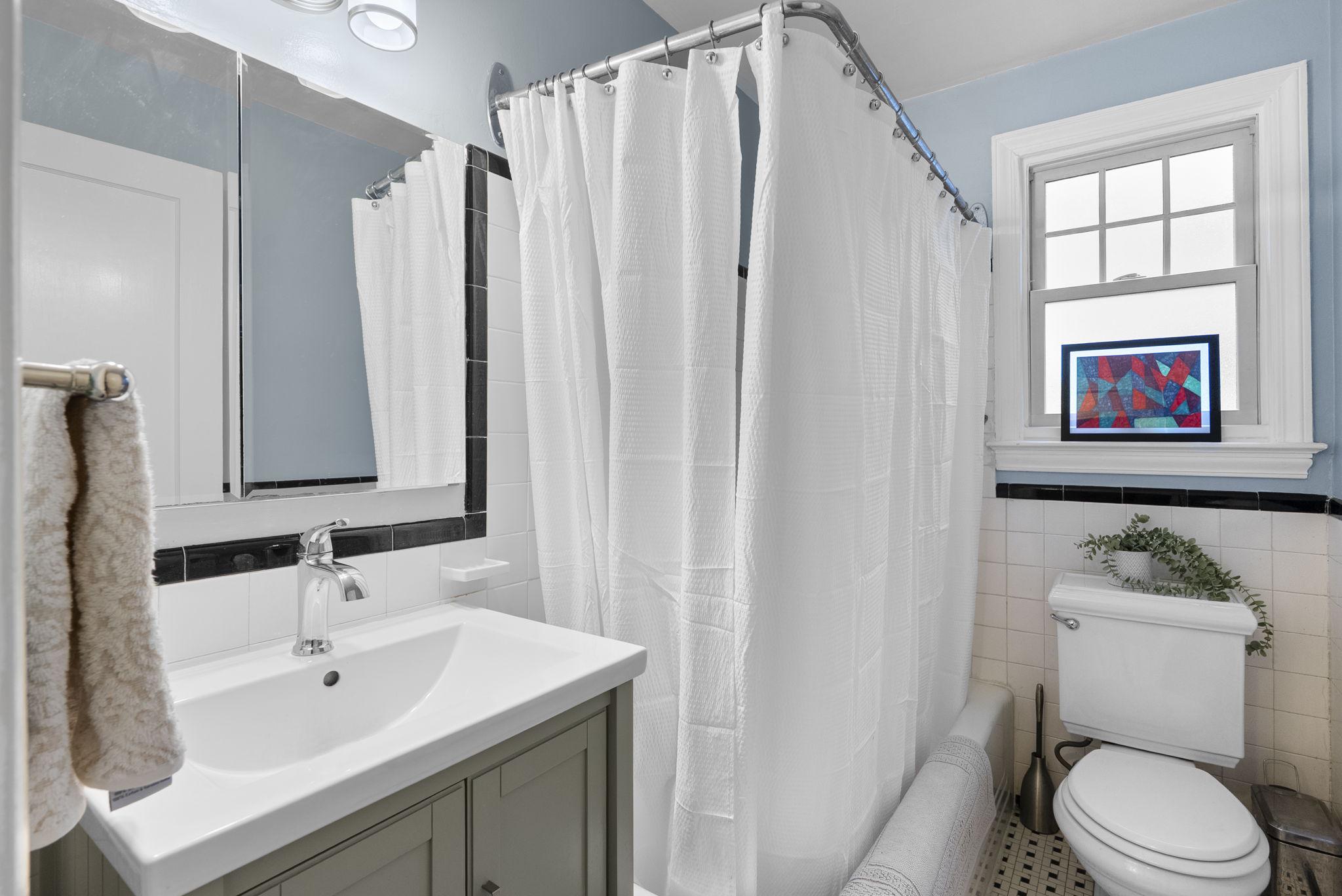 713 Gist Avenue Silver Spring, MD 20910 - Photo 12 of 35 a bathroom with a sink a mirror a toilet and a window