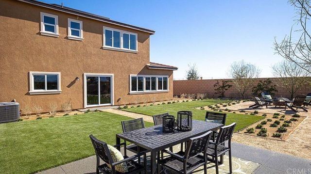 a view of a house with backyard and sitting area
