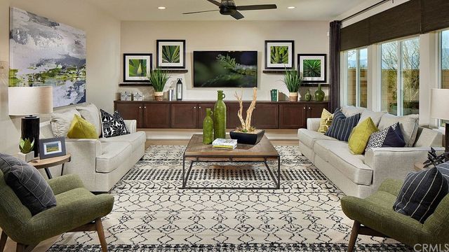 a living room with furniture a flat screen tv and a floor to ceiling window