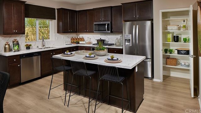 a kitchen with stainless steel appliances a table chairs refrigerator and microwave
