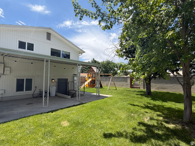 375 East 10560 South Sandy, UT 84070 - Photo 17 of 21 Spacious backyard featuring a concrete patio with an overhead cover, a manicured lawn, and mature trees