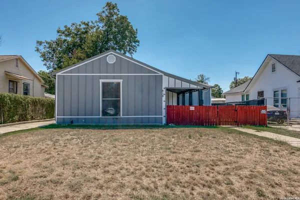 a front view of a house with yard and trees