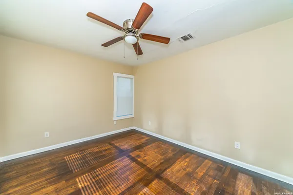 a view of a big room with wooden floor and windows