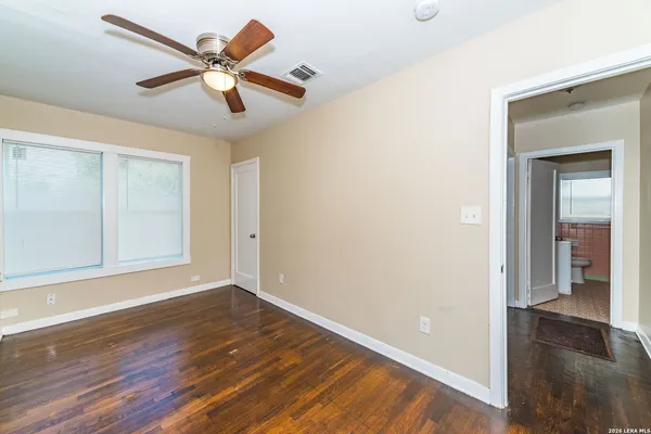 a view of a big room with wooden floor and a ceiling fan