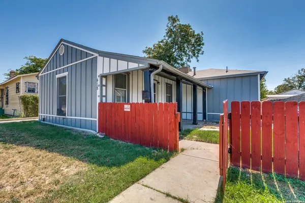 a view of a house with a small yard and wooden fence