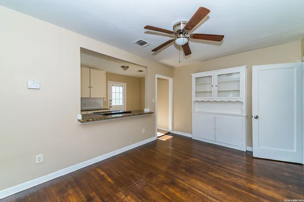 a view of a room with wooden floor and ceiling fan
