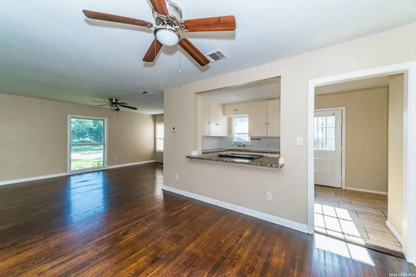 a view of a kitchen with wooden floor and a ceiling fan