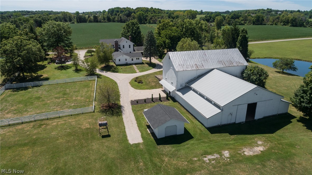 Here is an overhead view of the indoor arena, 5-10 stall barn, greenhouse cottage with new roof (tool room, garden room, summer kitchen, & greenhouse), one of the pastures, part of the 10 acre pond plus towards the back of this photo you can see the separate 934 sq ft ranch-style guest /in-law house and the 2-story 2924 sq ft fully updated main house