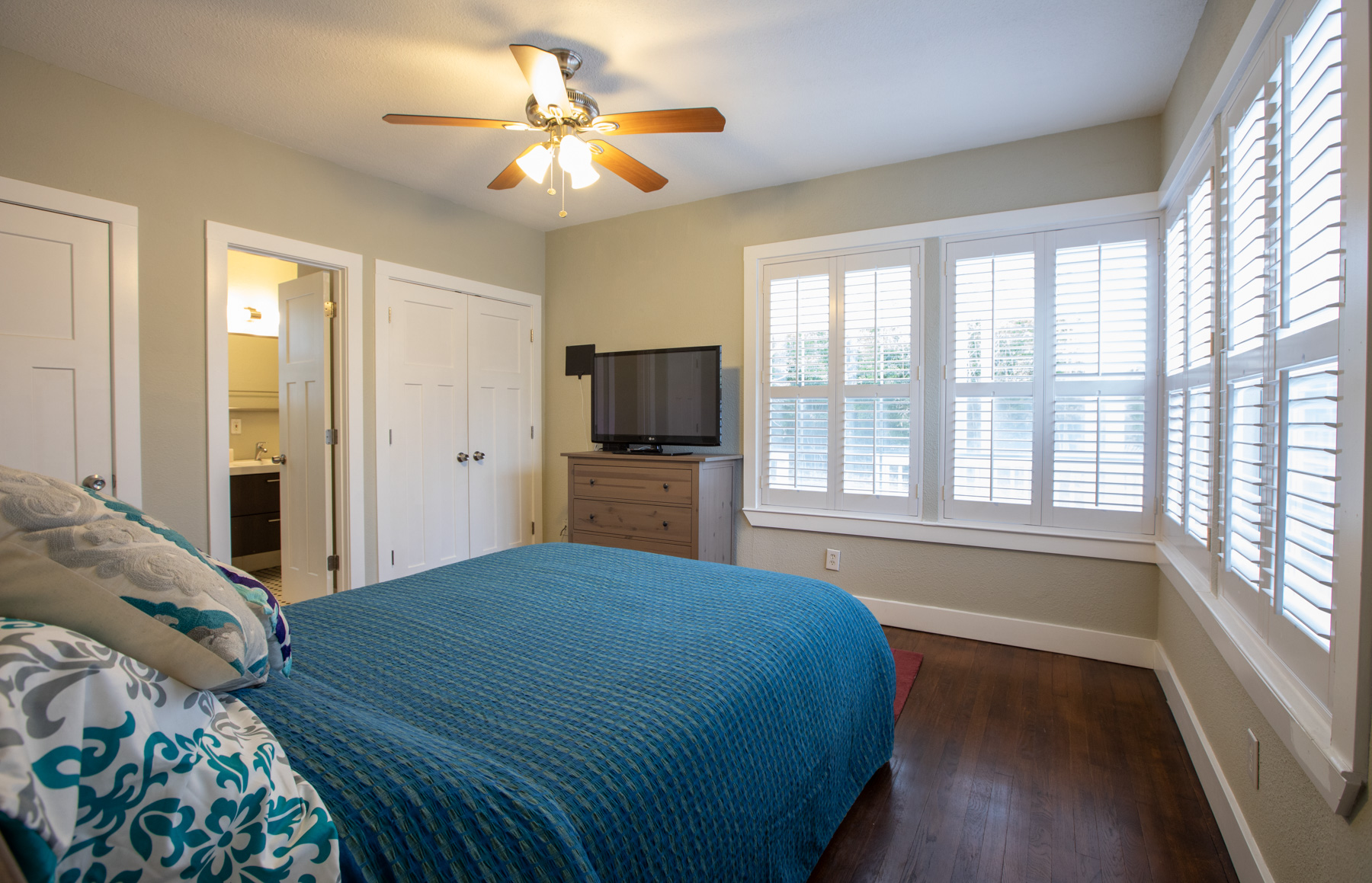 702 West N Loop Boulevard Austin, TX 78751 - Photo 3 of 23 Hardwood floors and a ceiling fan create a comfortable atmosphere in this well-appointed room.