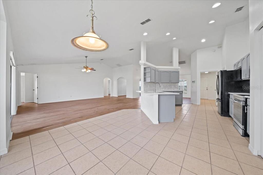 5659 Southwest 89th Place Ocala, FL 34476 - Photo 15 of 76 a large kitchen with stainless steel appliances kitchen island granite countertop a refrigerator a stove a oven and a sink with granite countertops