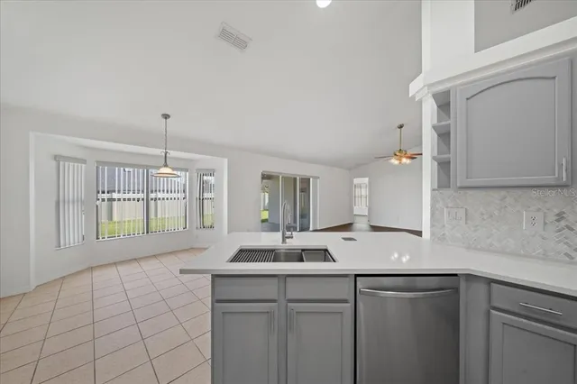 a view of empty room with wooden floor and ceiling fan