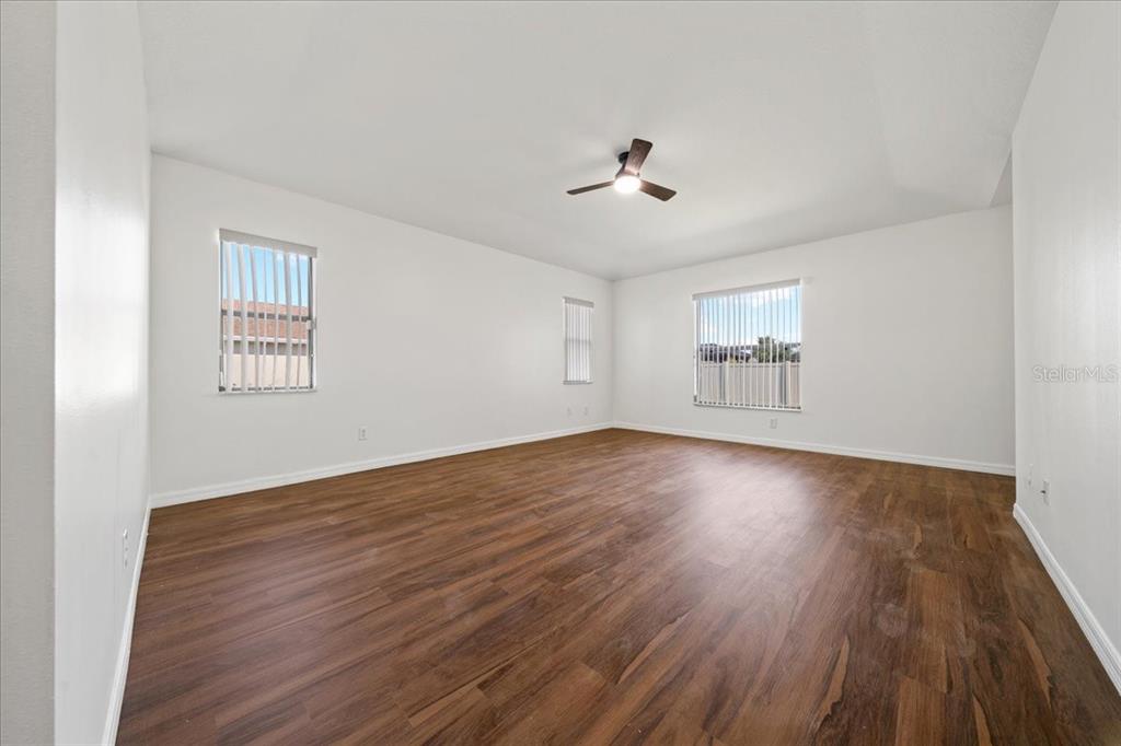 5659 Southwest 89th Place Ocala, FL 34476 - Photo 23 of 76 a view of empty room with wooden floor and fan