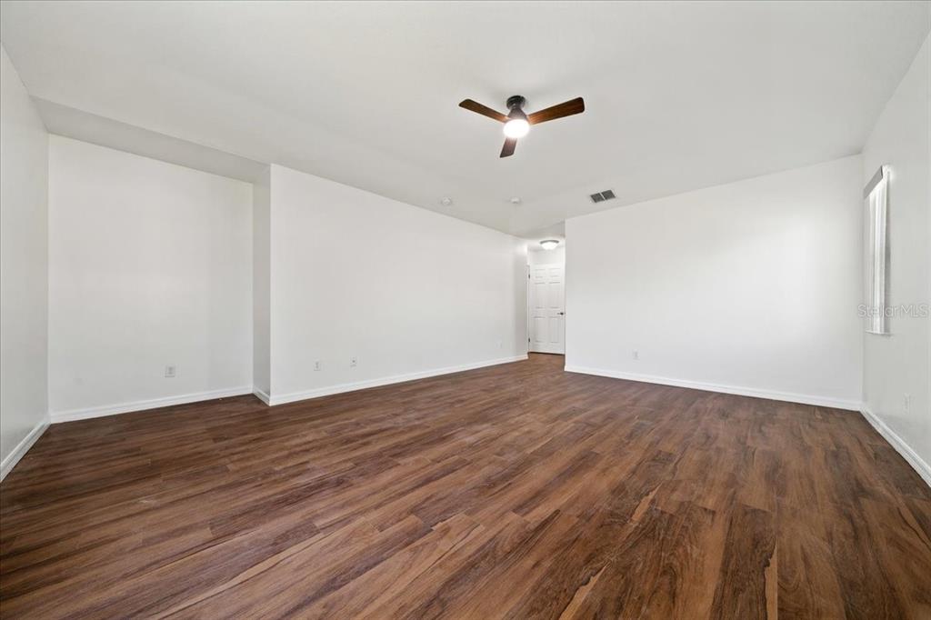 5659 Southwest 89th Place Ocala, FL 34476 - Photo 25 of 76 a view of empty room with wooden floor and ceiling fan