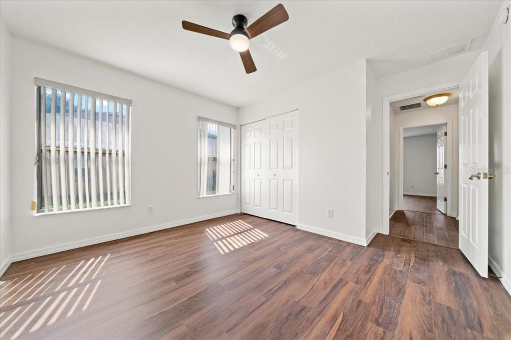 5659 Southwest 89th Place Ocala, FL 34476 - Photo 41 of 76 an empty room with wooden floor fan and windows