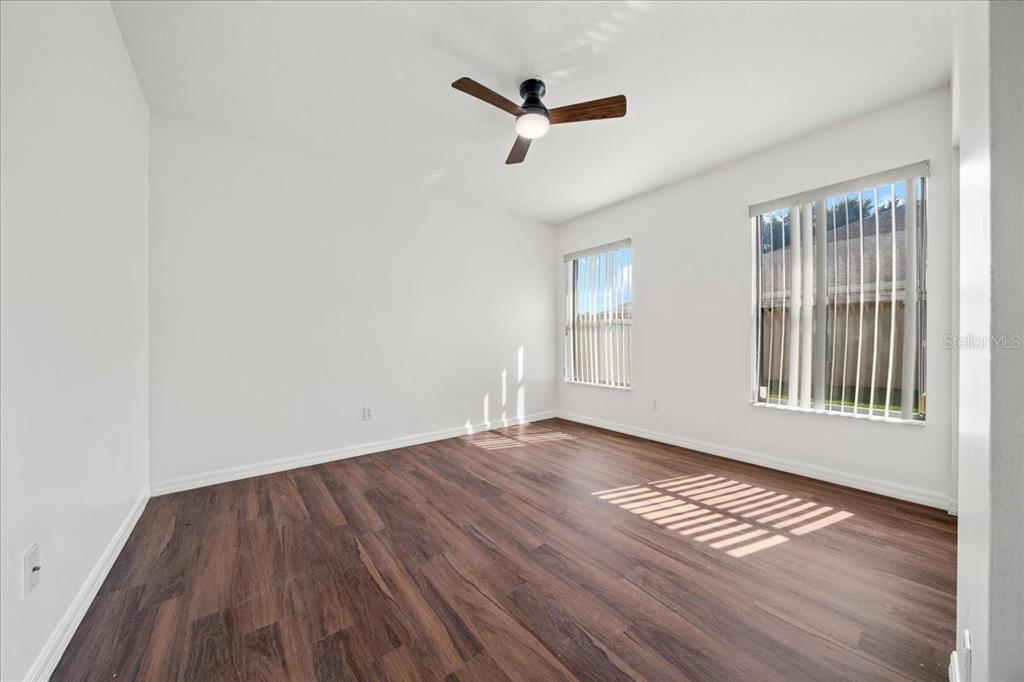 5659 Southwest 89th Place Ocala, FL 34476 - Photo 42 of 76 a view of empty room with wooden floor and fan
