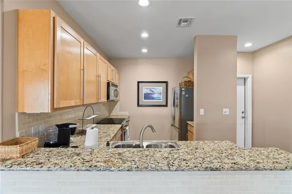 a kitchen with sink refrigerator and microwave