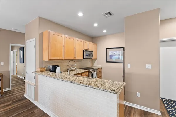 a kitchen with stainless steel appliances granite countertop refrigerator sink and cabinets