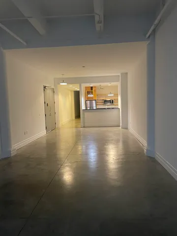 a view of a hallway with kitchen area and appliances