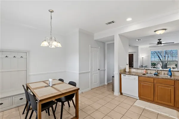a room with a table chairs and chandelier