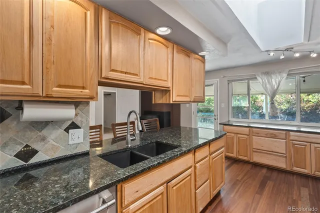 a kitchen with stainless steel appliances granite countertop a sink a stove and cabinets
