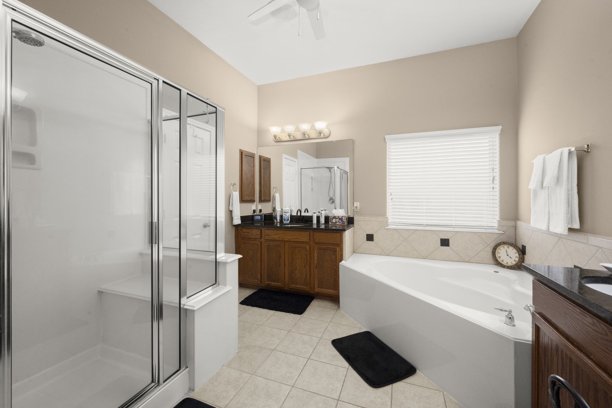 6315 Amelia Springs Drive Spring, TX 77379 - Photo 17 of 46 The Primary bathroom is spacious and features a glass-enclosed shower, a large soaking tub, and dual sinks with granite countertops. The neutral color palette and ample lighting create a bright and inviting atmosphere.