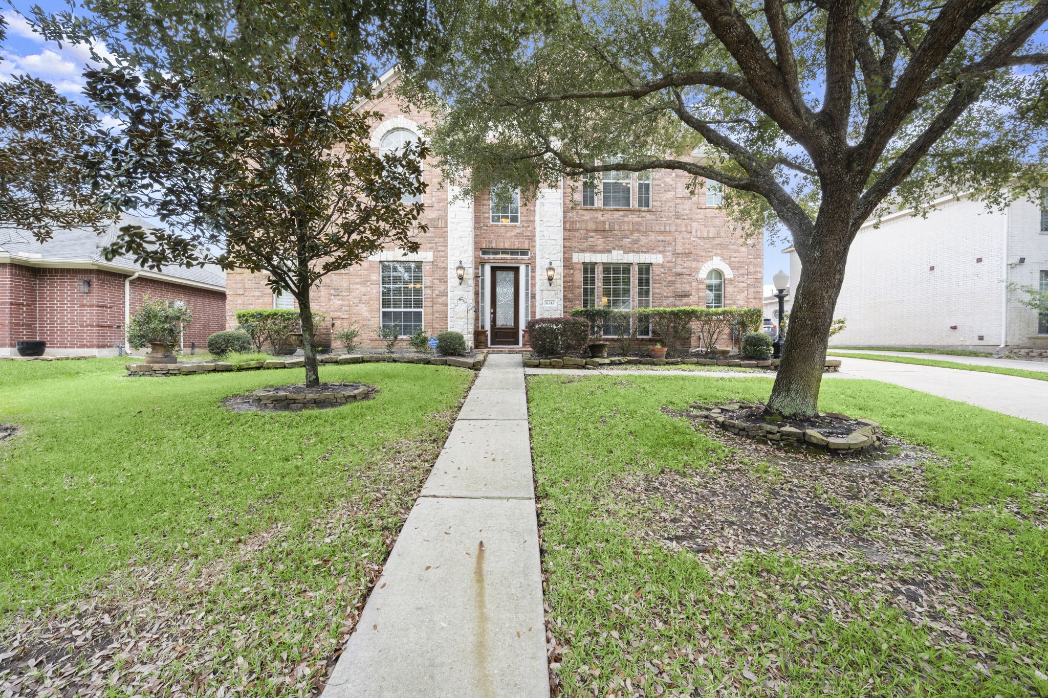 6315 Amelia Springs Drive Spring, TX 77379 - Photo 6 of 46 Charming brick home with a well-maintained front yard. A paved walkway leads to the entrance, with mature trees and neatly trimmed shrubs. The exterior features large windows and a welcoming atmosphere, ideal for a family residence.