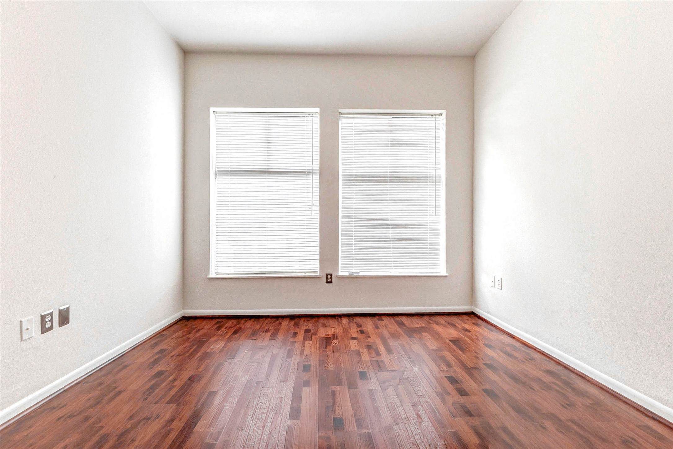 3505 Sage Road, Unit 1104 Houston, TX 77056 - Photo 16 of 31 This view highlights the depth and openness of the bedroom as it stretches toward two large windows that fill the room with natural light. The beautiful wood flooring reflects the sunlight, enhancing the warmth and inviting feel of the space. With its generous proportions and simple design, the room provides endless possibilities for furniture placement while maintaining a bright and relaxing environment.