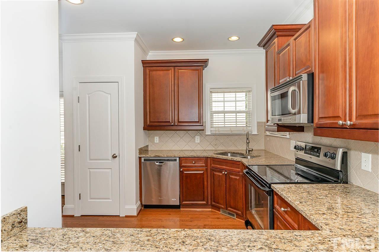1217 Harp Street Raleigh, NC 27604 - Photo 12 of 27 a kitchen with stainless steel appliances granite countertop a sink stove and refrigerator