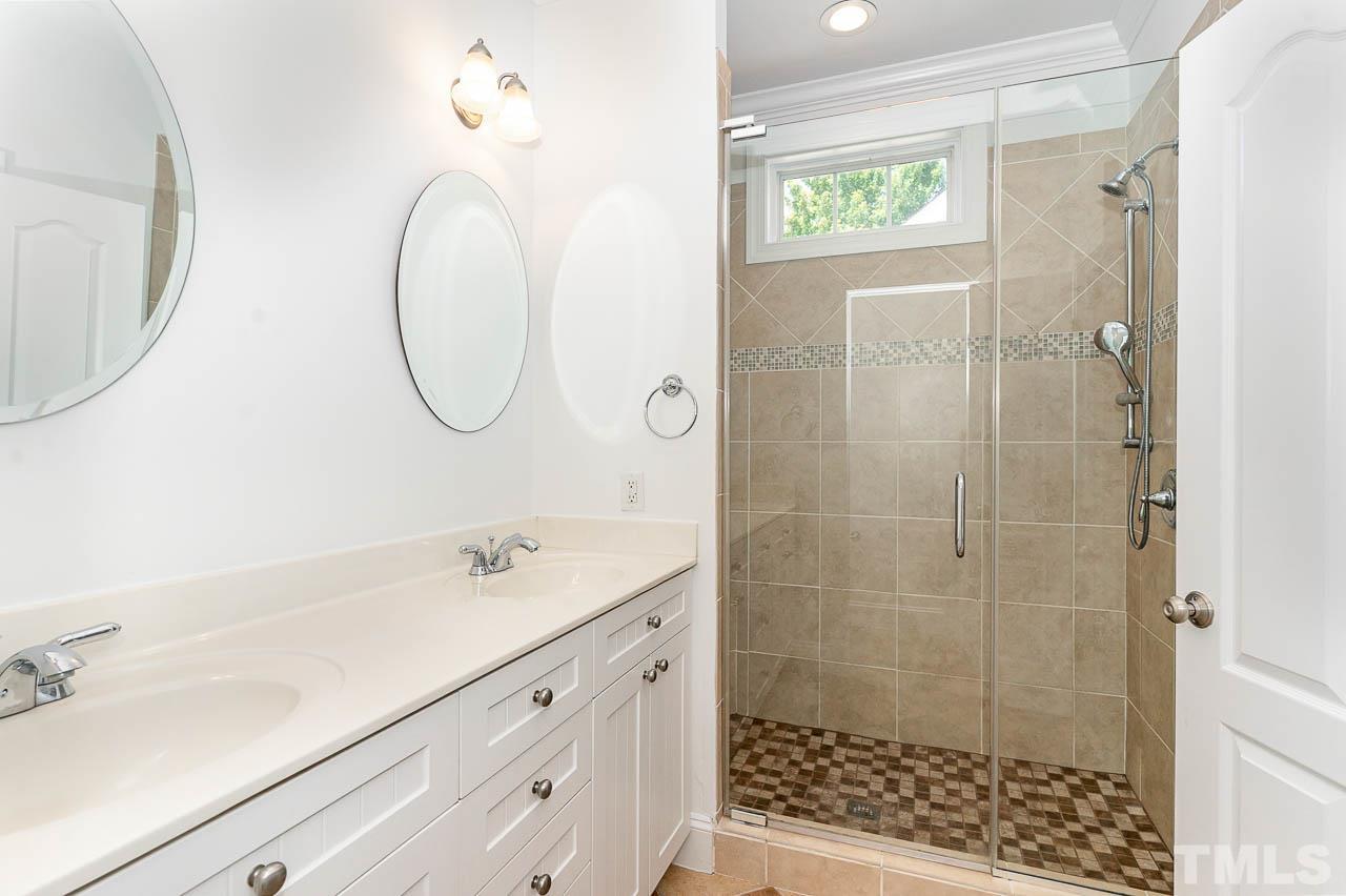 1217 Harp Street Raleigh, NC 27604 - Photo 15 of 27 a bathroom with a shower a sink and a mirror