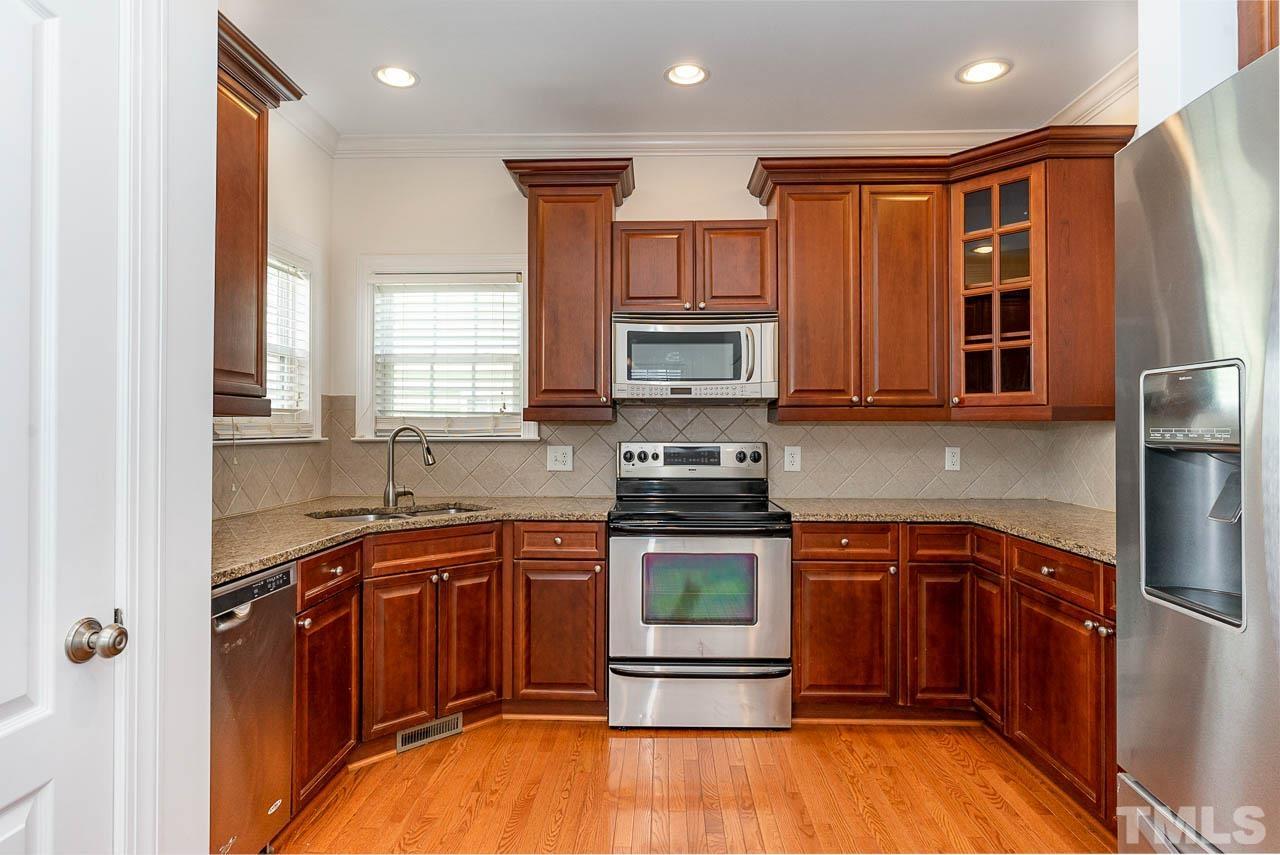 1217 Harp Street Raleigh, NC 27604 - Photo 8 of 27 a kitchen with stainless steel appliances granite countertop a stove top oven a sink and dishwasher