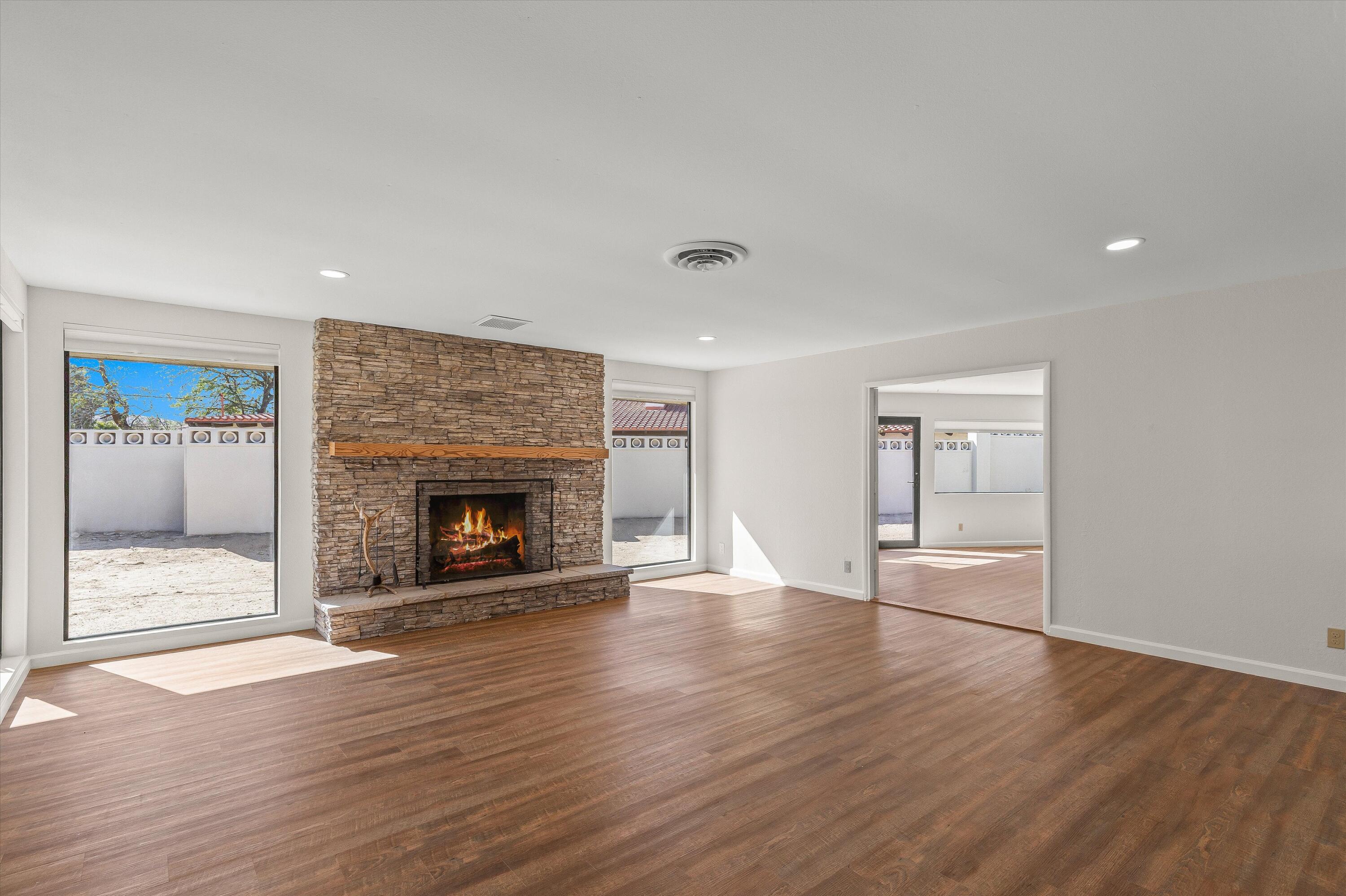 7458 Cardillo Trail Yucca Valley, CA 92284 - Photo 12 of 47 a view of an empty room with wooden floor fireplace and a window