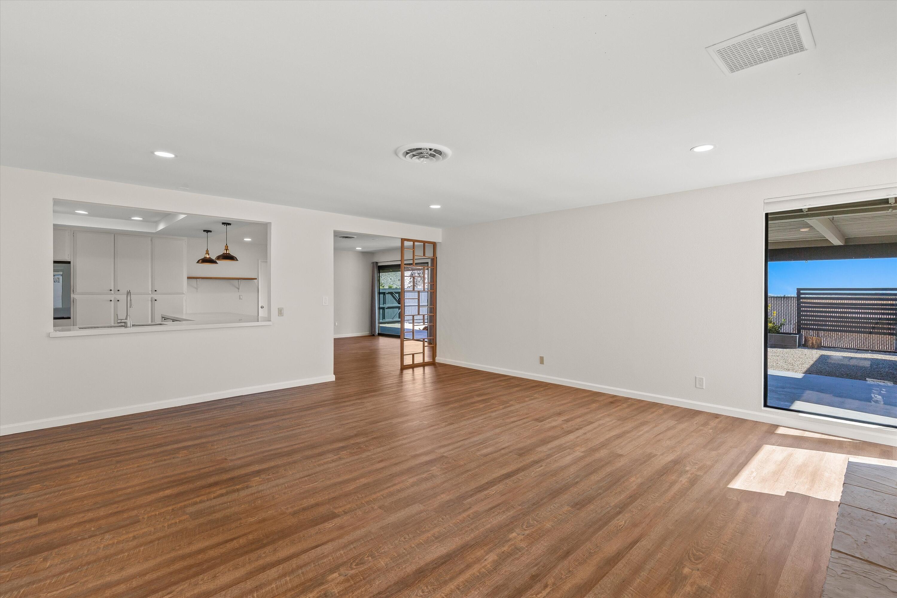 7458 Cardillo Trail Yucca Valley, CA 92284 - Photo 14 of 47 a view of an empty room with wooden floor and a window
