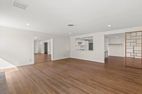 a view of empty room with wooden floor and fireplace