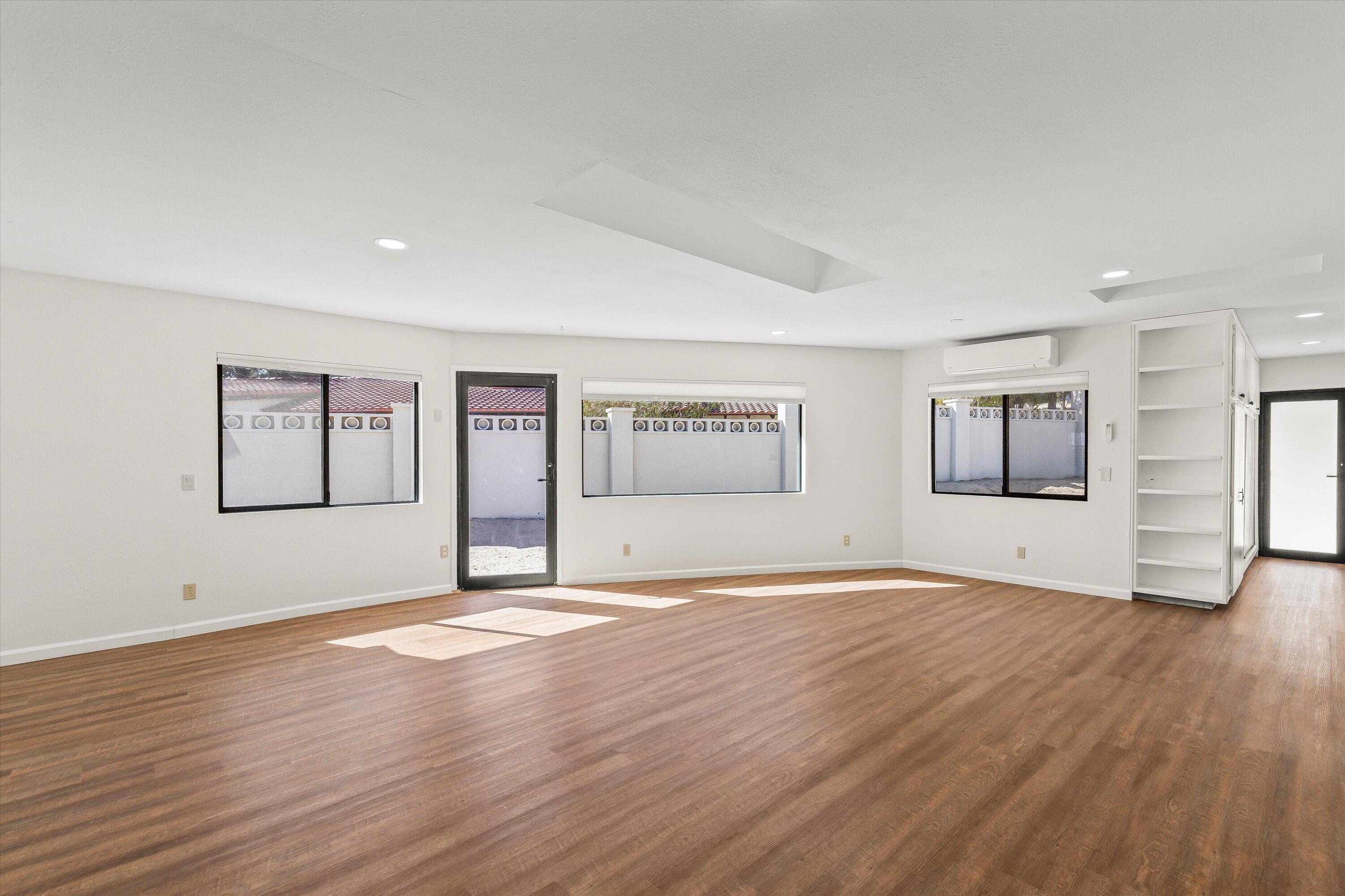 7458 Cardillo Trail Yucca Valley, CA 92284 - Photo 16 of 47 a view of an empty room with window and wooden floor
