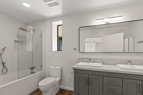 a bathroom with a granite countertop toilet sink and mirror