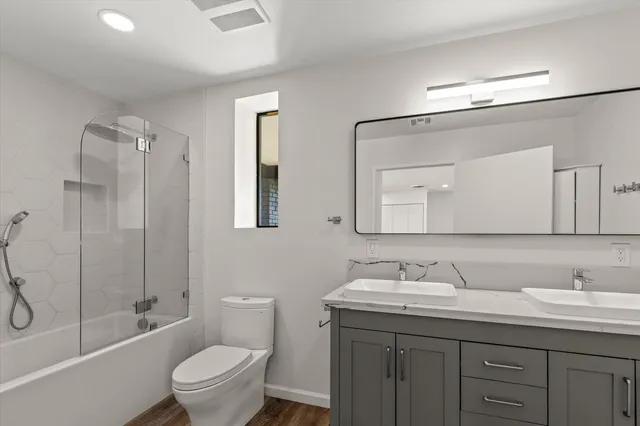 a bathroom with a granite countertop toilet sink and mirror