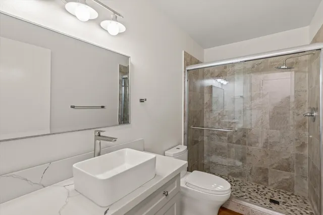 a bathroom with a sink toilet and shower