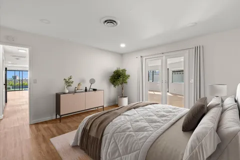 a bedroom with a large bed and wooden floor